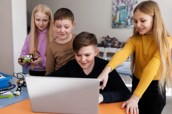 Four kids using a laptop and doing coding